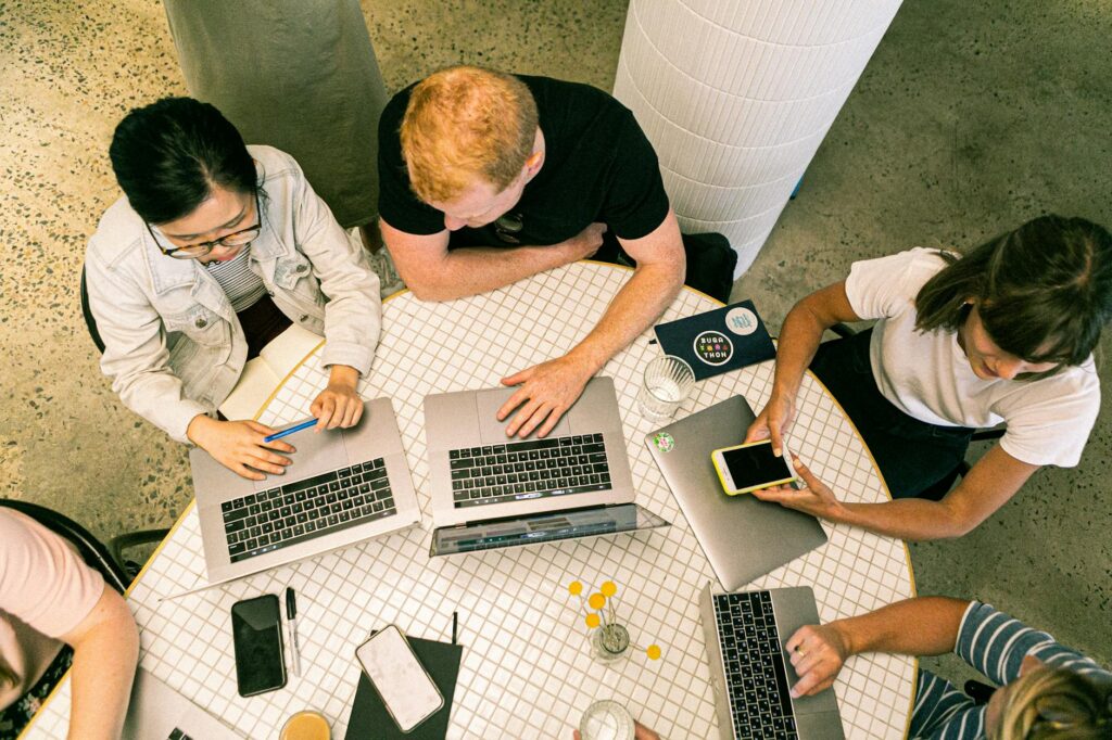 Business professionals discussing strategies to Hire SEO Agency, with laptops and digital marketing charts in the background.